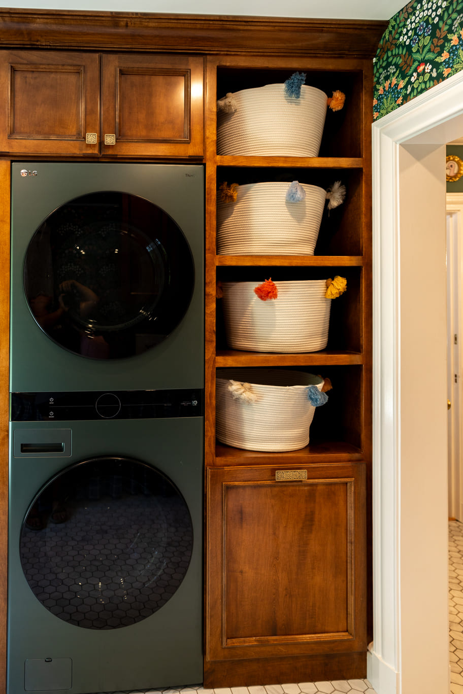 Laundry room with green appliences and wooden shelving and cabinetry with wallpaper