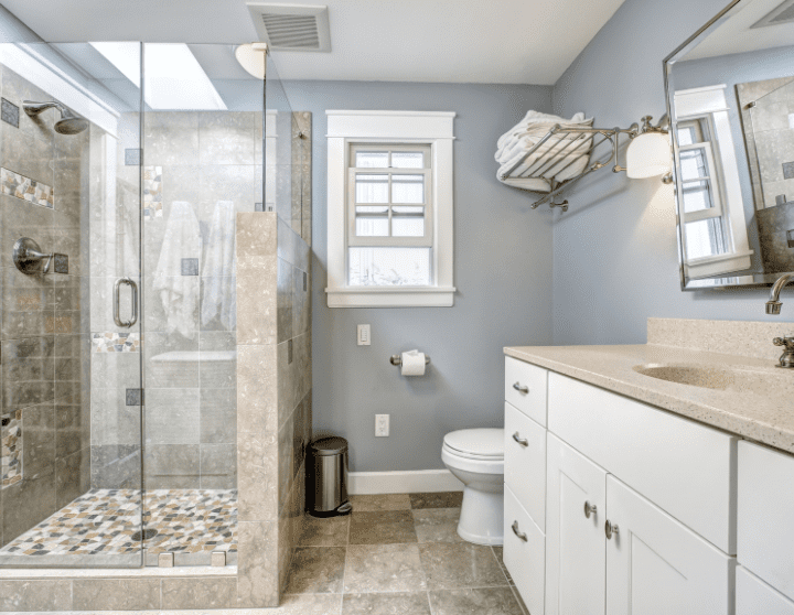 bathroom with white cabinets and walk in shower