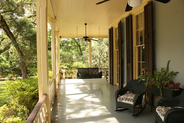 a porch with two chairs and a ceiling fan