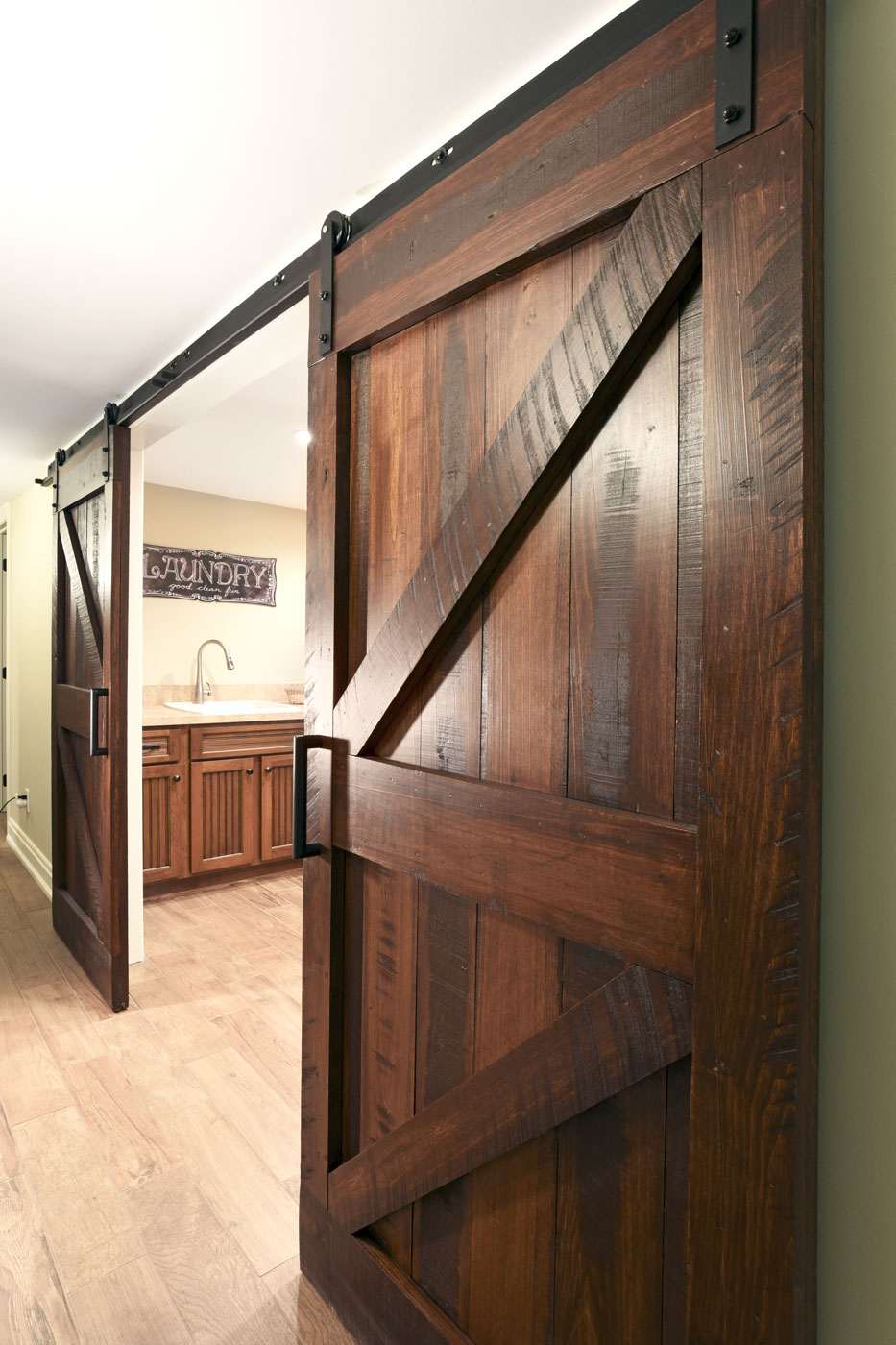 Dark wood basement barn doors with matte black handles by True Craft Remodelers, Central Illiniois 