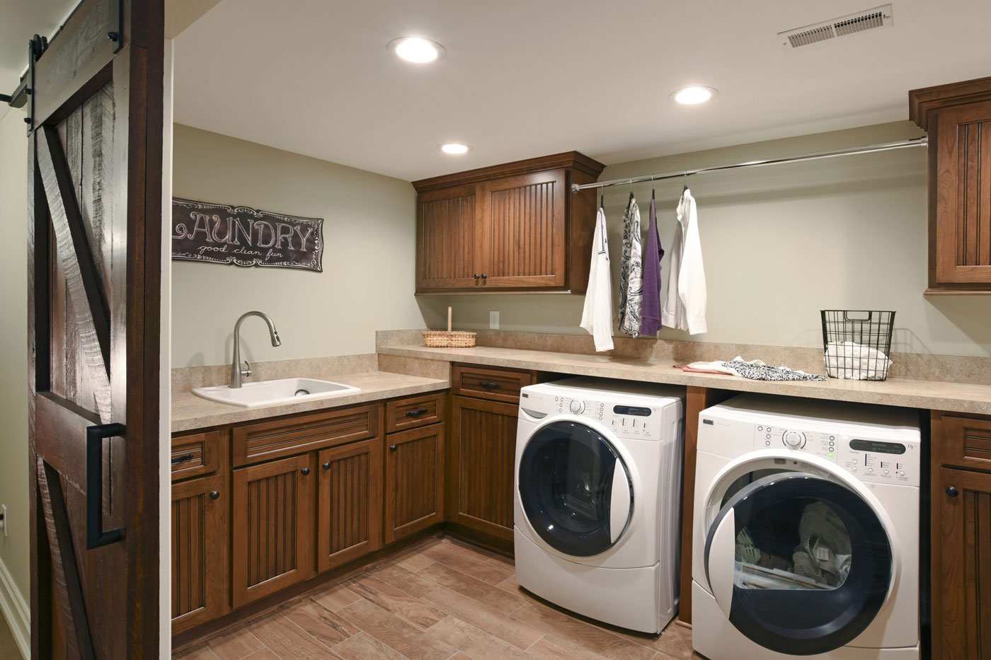 Remodeled basement laundry room with high-end appliances and new cabinets