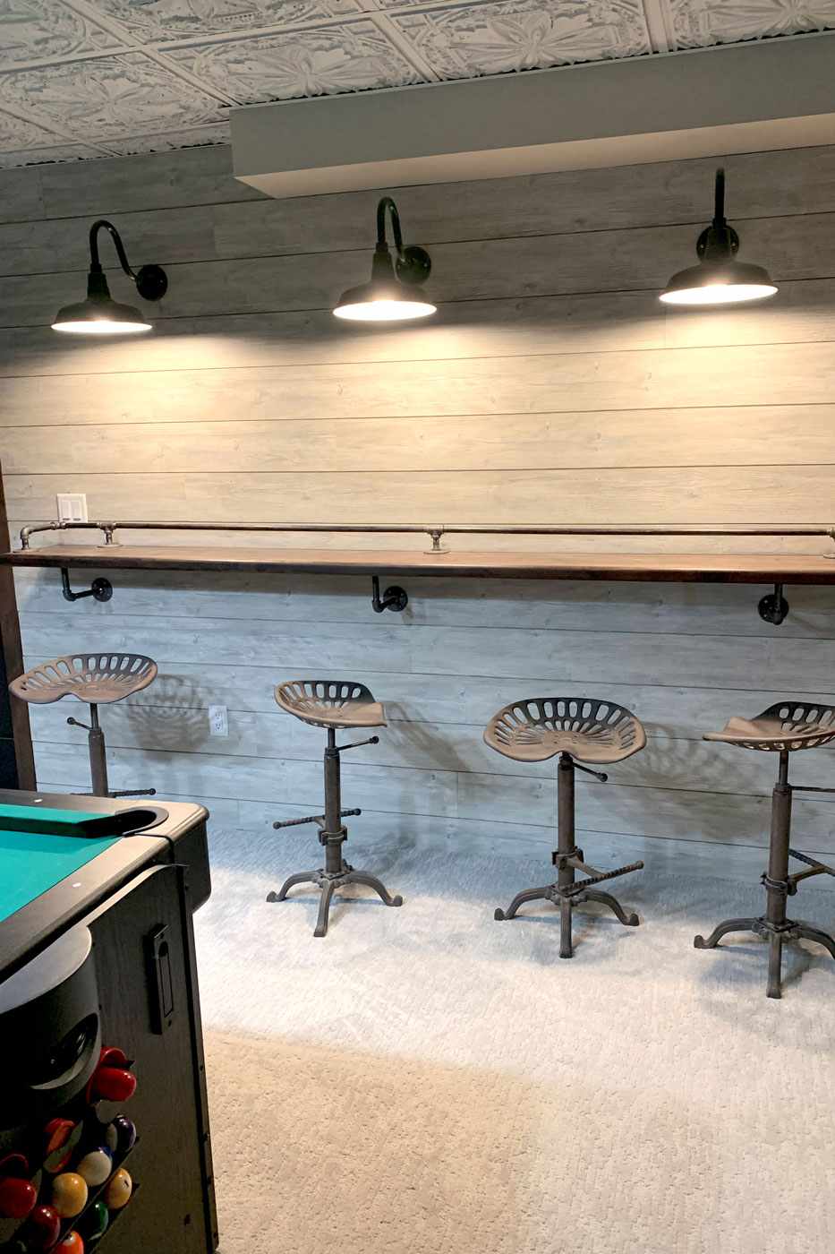 basement with bar stools & pool table by True Craft Remodelrs in Illinois