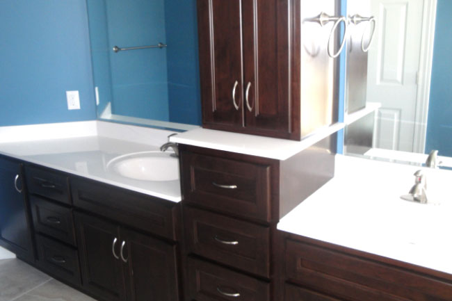 Bathroom counter with dark wood cabinets, double sinks and lots of storage by True Craft Remodelrs in Illinois