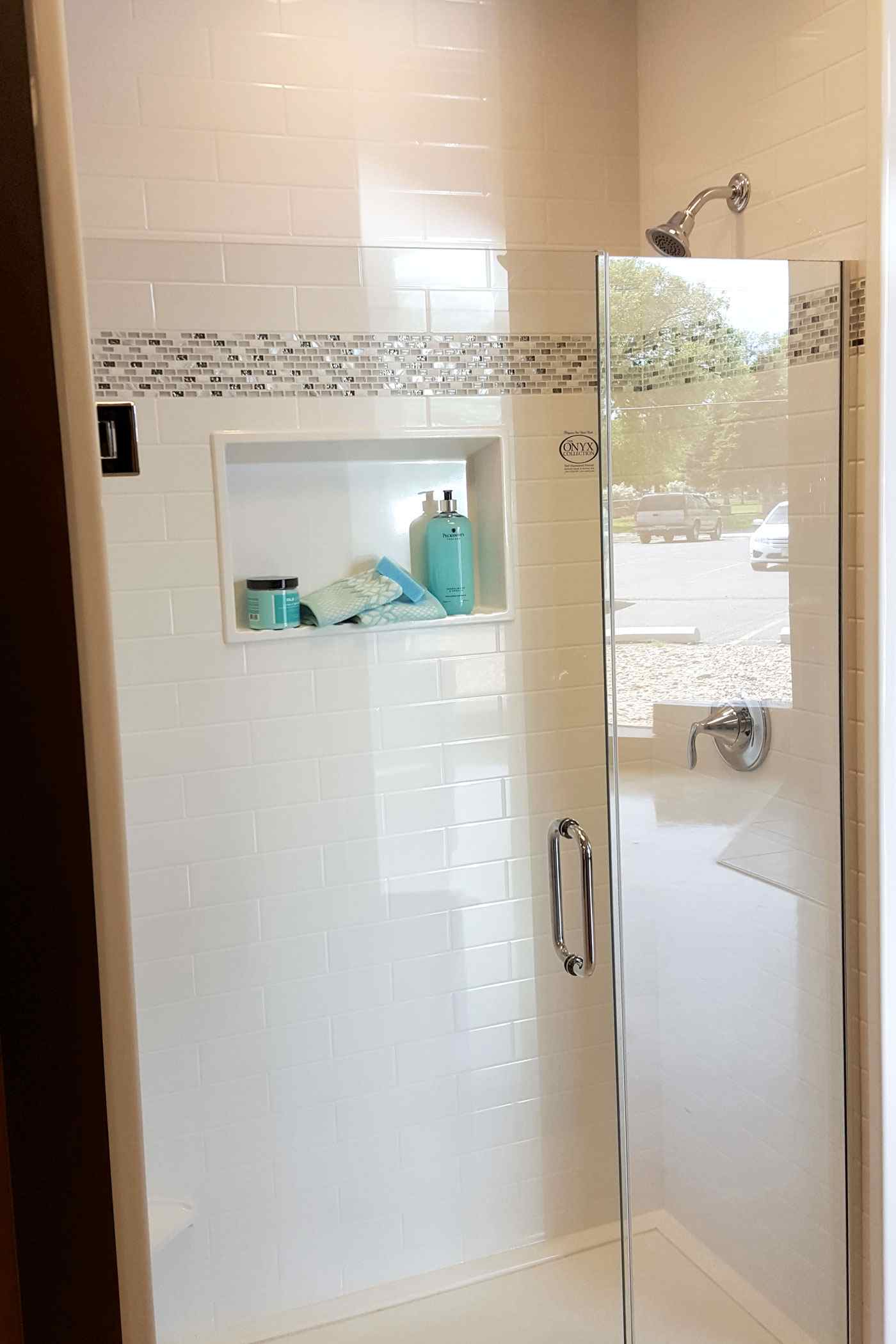 New show with glass door, built-in shelf and mosaic tile installed by True Craft Remodelers